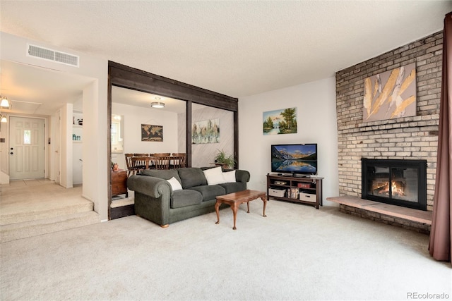 living room with light colored carpet, a fireplace, and a textured ceiling