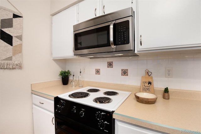 kitchen featuring black / electric stove, backsplash, and white cabinets