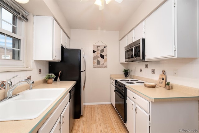 kitchen with sink, white cabinetry, tasteful backsplash, light hardwood / wood-style flooring, and stainless steel appliances