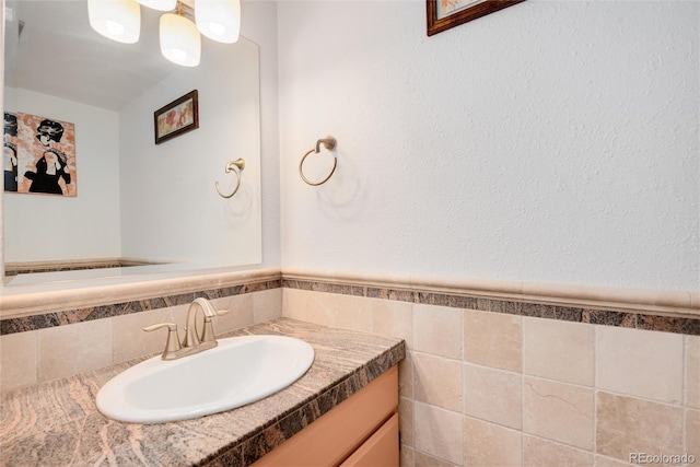 bathroom with vanity and tile walls