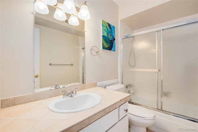 full bathroom featuring vanity, combined bath / shower with glass door, toilet, and an inviting chandelier