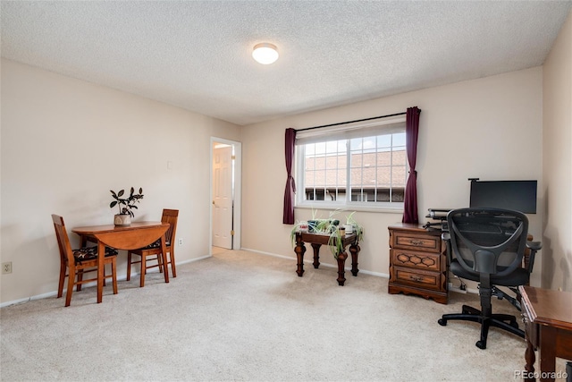 home office featuring light colored carpet and a textured ceiling