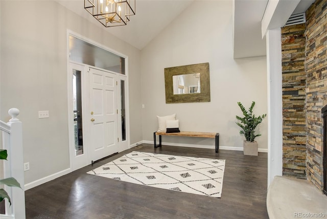 entryway featuring baseboards, high vaulted ceiling, dark wood finished floors, and a notable chandelier