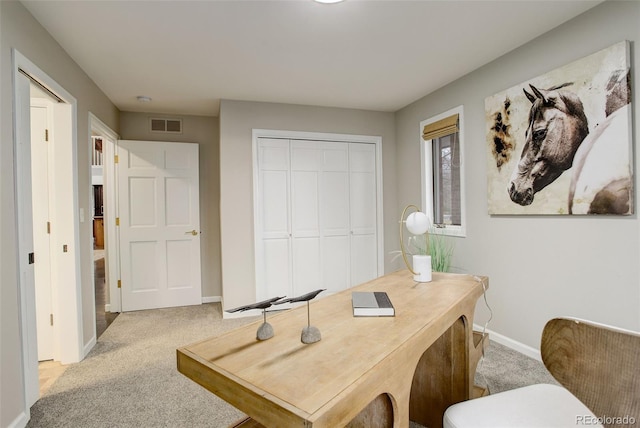 home office with light carpet, visible vents, and baseboards