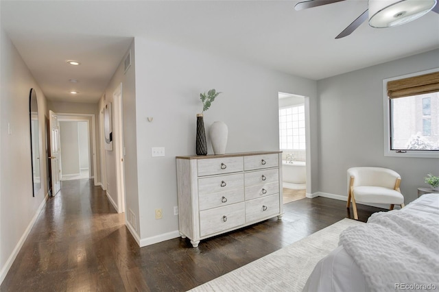 bedroom with ceiling fan, ensuite bath, dark wood finished floors, and baseboards