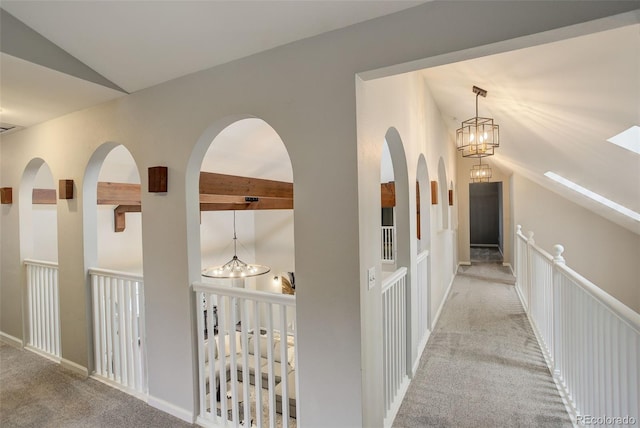 hallway featuring light carpet, a notable chandelier, and lofted ceiling with beams