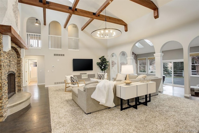 living room featuring a wealth of natural light, a fireplace, wood finished floors, and visible vents