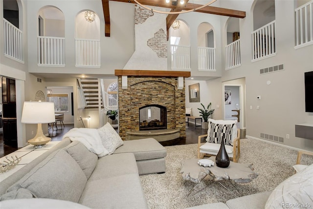 living room featuring stairway, a fireplace, visible vents, and baseboards