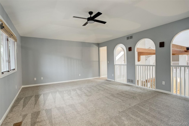 unfurnished room with carpet, visible vents, and baseboards