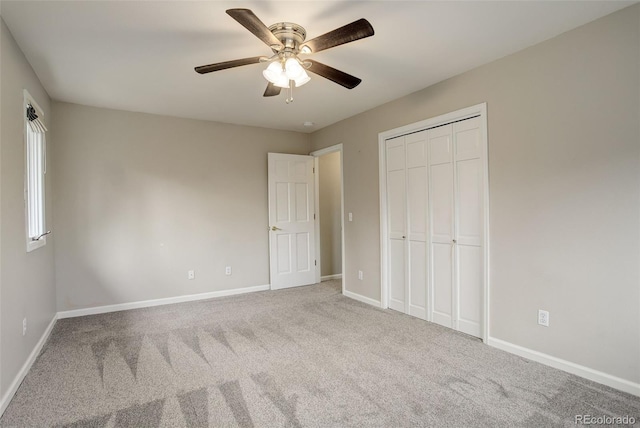 unfurnished bedroom featuring a closet, carpet flooring, a ceiling fan, and baseboards