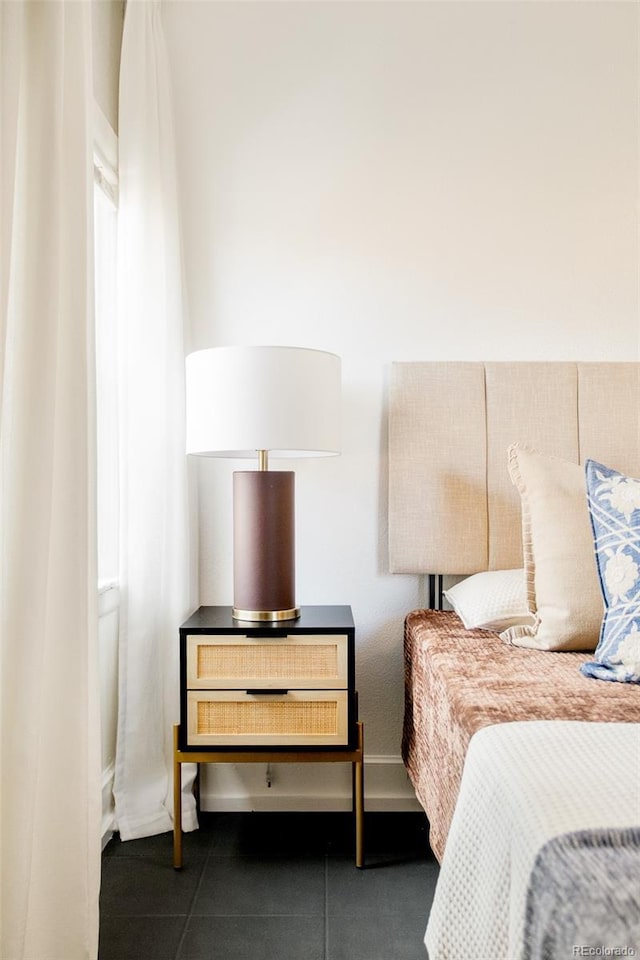 bedroom featuring dark tile patterned floors and baseboards