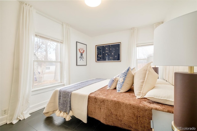 bedroom featuring multiple windows, baseboards, and tile patterned floors