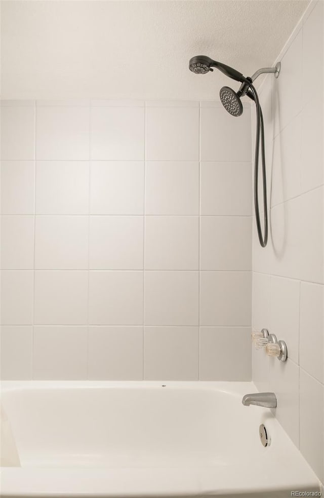 bathroom featuring a textured ceiling and shower / tub combination