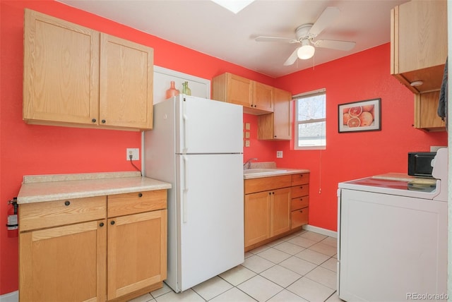 kitchen featuring light brown cabinets, a sink, light countertops, freestanding refrigerator, and washer / dryer