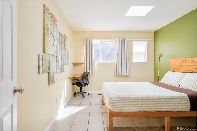 bedroom with light tile patterned floors, baseboards, and a skylight