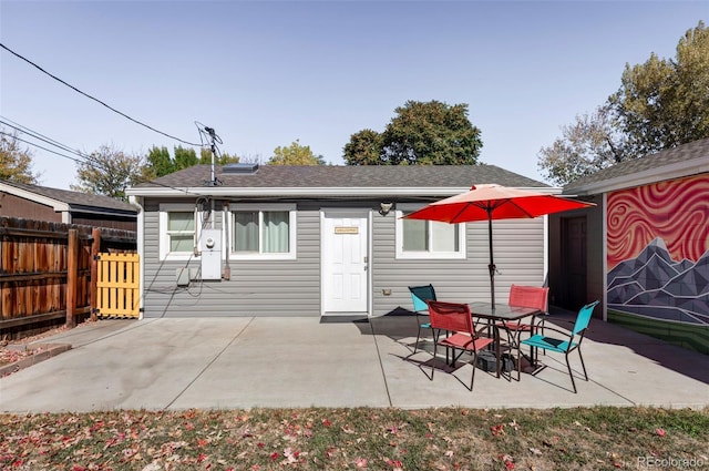 rear view of house with fence and a patio