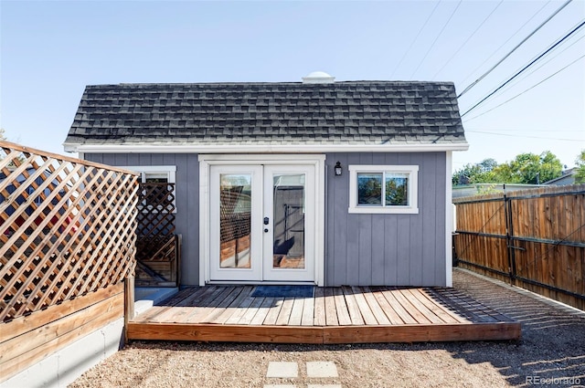 view of outdoor structure with french doors and fence