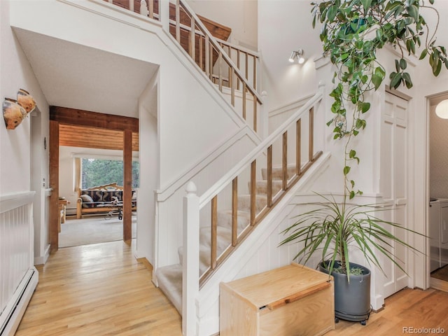 staircase featuring a baseboard radiator and wood finished floors