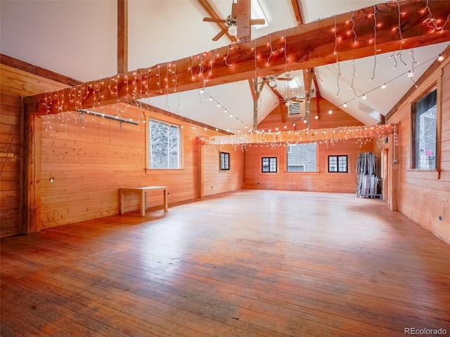 bonus room featuring wooden walls, wood-type flooring, and beam ceiling