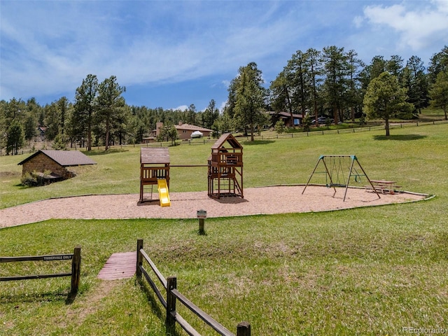 community jungle gym featuring a yard and fence