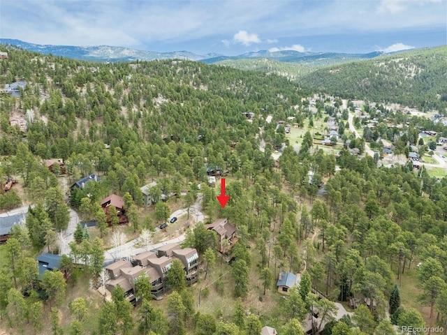 aerial view featuring a wooded view and a mountain view