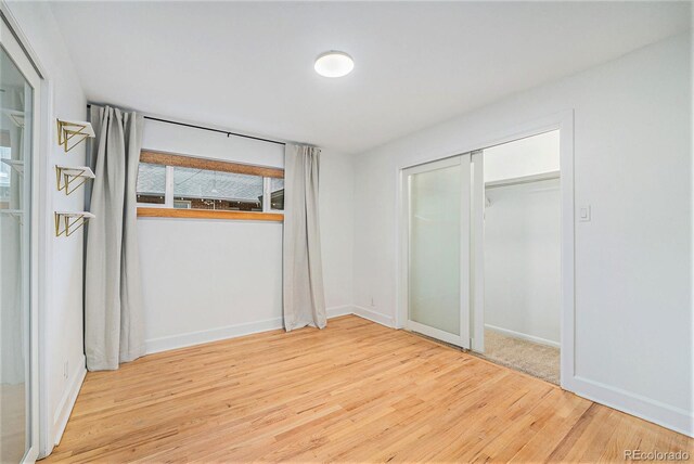 1111 Monroe St, Denver, CO 80206 - unfurnished bedroom featuring wood finished floors, baseboards, and a closet
