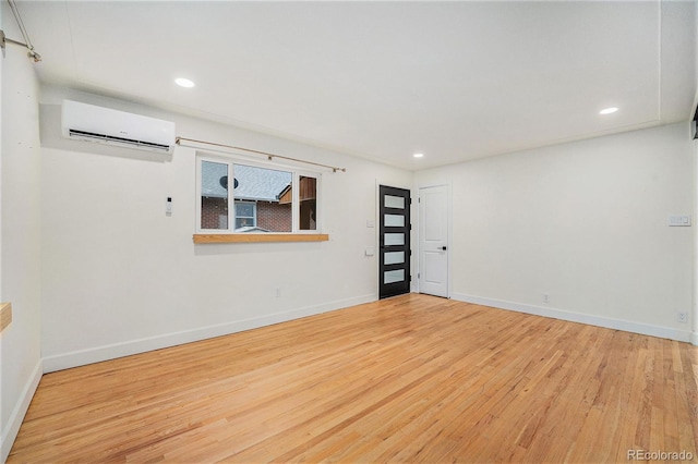 1111 Monroe St, Denver, CO 80206 - spare room featuring a wall unit AC, wood finished floors, baseboards, and recessed lighting