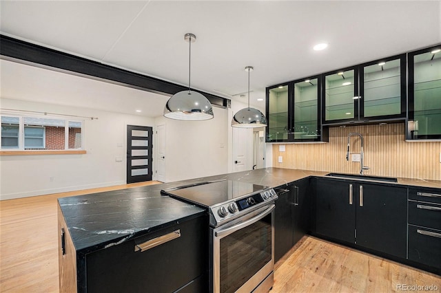 1111 Monroe St, Denver, CO 80206 - kitchen featuring electric stove, a sink, dark cabinets, light wood finished floors, and pendant lighting