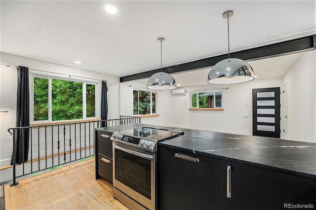 1111 Monroe St, Denver, CO 80206 - kitchen with electric stove, dark cabinets, a wall mounted AC, light wood finished floors, and dark countertops