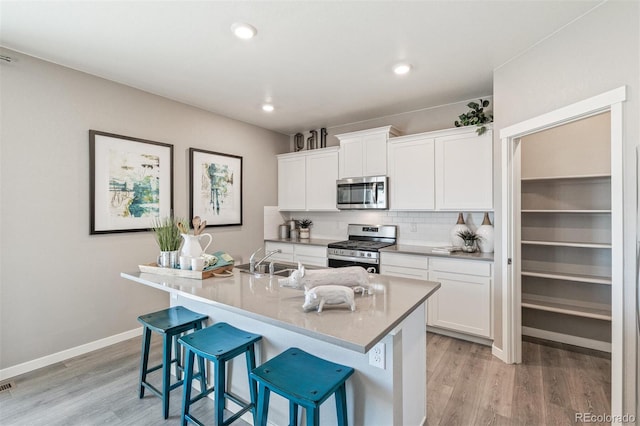 18150 Coppermallow Trl, Parker, CO 80134 - kitchen featuring stainless steel appliances, light wood-style flooring, a breakfast bar area, backsplash, and recessed lighting