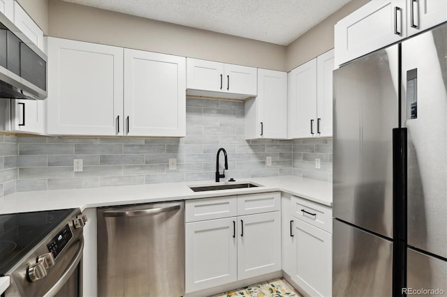 kitchen with tasteful backsplash, white cabinetry, appliances with stainless steel finishes, and sink