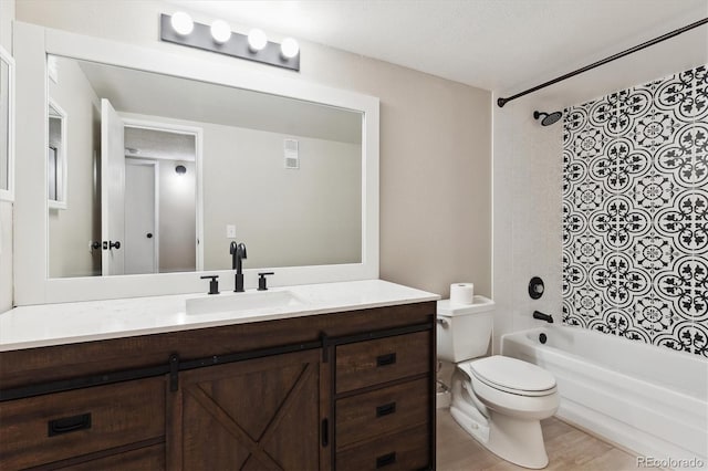 full bathroom with vanity, tiled shower / bath combo, and toilet