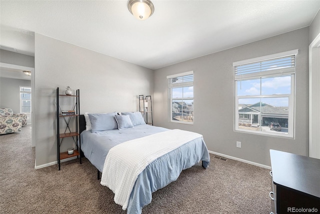 carpeted bedroom with visible vents and baseboards