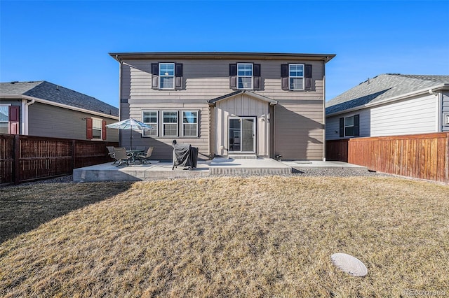 rear view of property featuring a fenced backyard, a patio, and a lawn