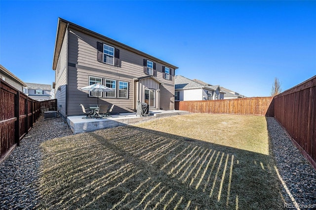 rear view of house featuring a fenced backyard and a patio