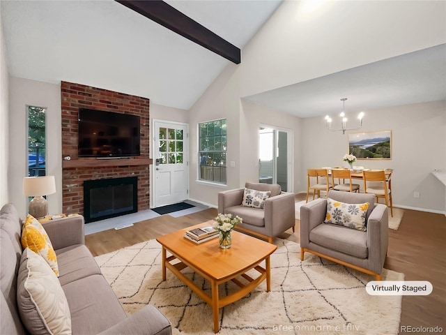 living room featuring light wood-type flooring, a chandelier, beamed ceiling, high vaulted ceiling, and a brick fireplace