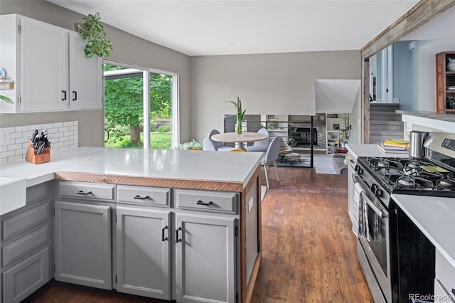 8764 W 95th Ave, Broomfield, CO 80021 - kitchen featuring stainless steel range with gas stovetop, a peninsula, tasteful backsplash, and light countertops