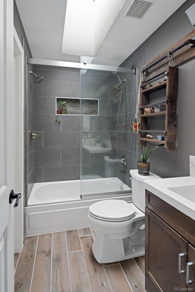 8764 W 95th Ave, Broomfield, CO 80021 - bathroom featuring bath / shower combo with glass door, toilet, wood finished floors, and vanity