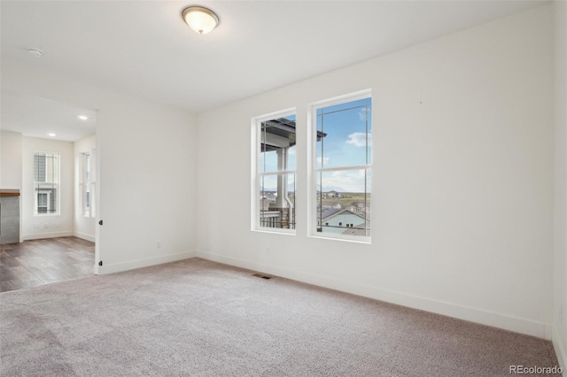 spare room featuring baseboards, carpet, recessed lighting, and visible vents