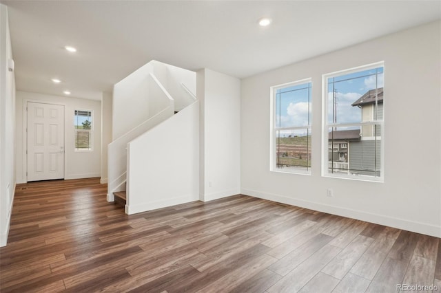 interior space with recessed lighting, baseboards, stairs, and wood finished floors