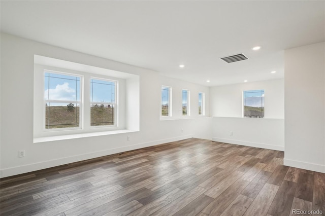 unfurnished room featuring visible vents, recessed lighting, baseboards, and wood finished floors
