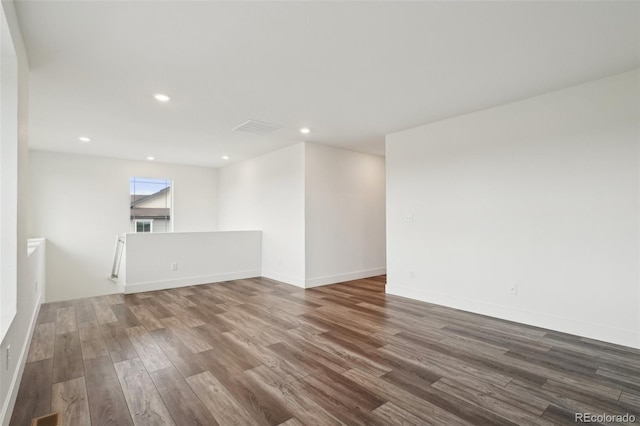 empty room with recessed lighting, baseboards, visible vents, and wood finished floors