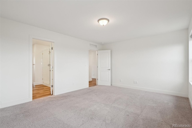 unfurnished bedroom with visible vents, carpet, ensuite bath, and baseboards