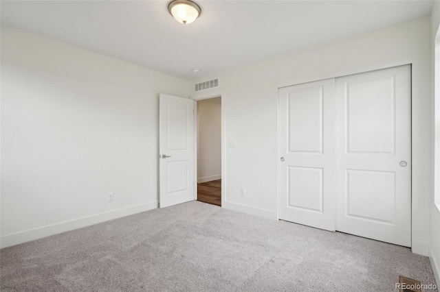 unfurnished bedroom with baseboards, carpet, visible vents, and a closet