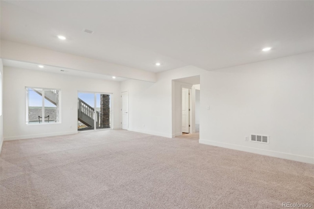 spare room featuring light colored carpet, baseboards, visible vents, and recessed lighting