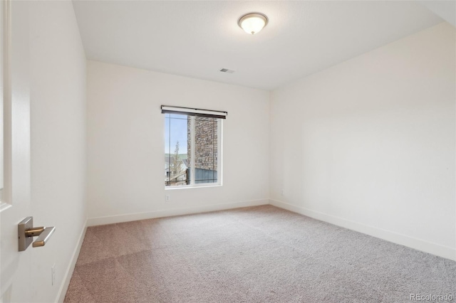 carpeted empty room featuring baseboards and visible vents