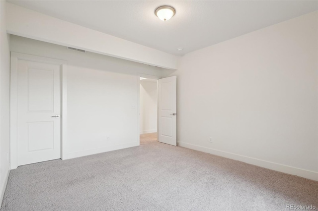 carpeted spare room with baseboards and visible vents