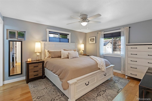 bedroom featuring light wood finished floors, ceiling fan, and baseboards