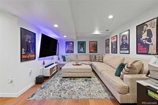 living room featuring baseboards, wood finished floors, and recessed lighting