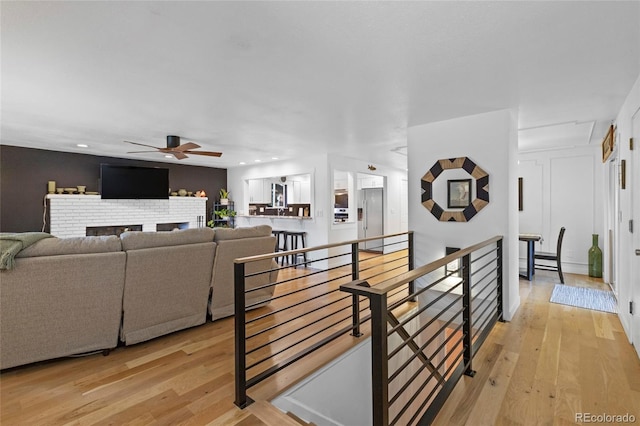 living room with light hardwood / wood-style floors and ceiling fan